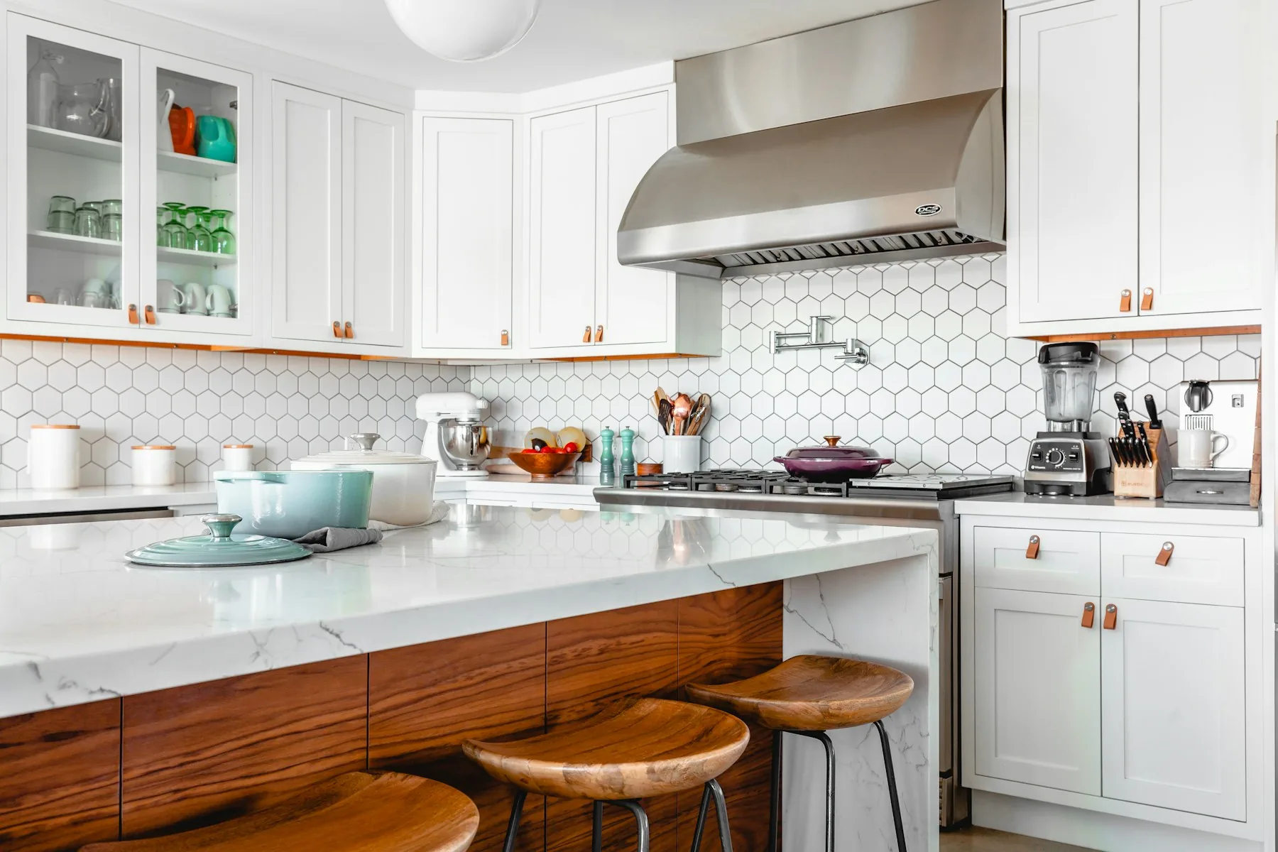 Bright white kitchen with patterned tile backsplash and a spacious central island